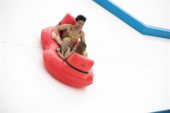Couple play slide up extreme water slide in Wild Wild Wet water park Singapore