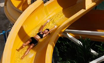 A woman enjoys the water works giant slide in Wild Wild Wet adventure water park Singapore
